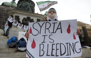 A Syrian living in Serbia displays a placard on March 16, 2013 during a protest against Syria's President Bashar al-Assad in the center of Belgrade. AFP PHOTO / ALEXA STANKOVIC (Photo credit should read ALEXA STANKOVIC/AFP/Getty Images)